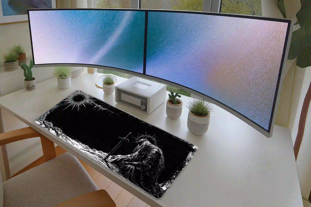 Fallen knight desk mat on a white workstation with two monitors, showing the armored figure beside an open black area
