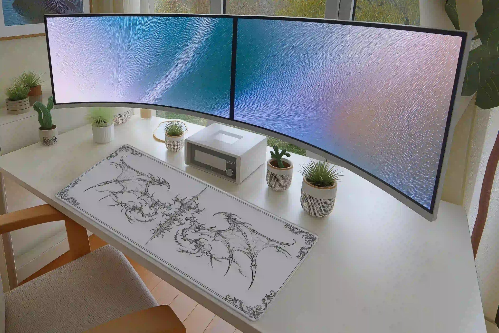 Full desk setup with the gothic winged cross skull line art mat beneath a keyboard and mouse