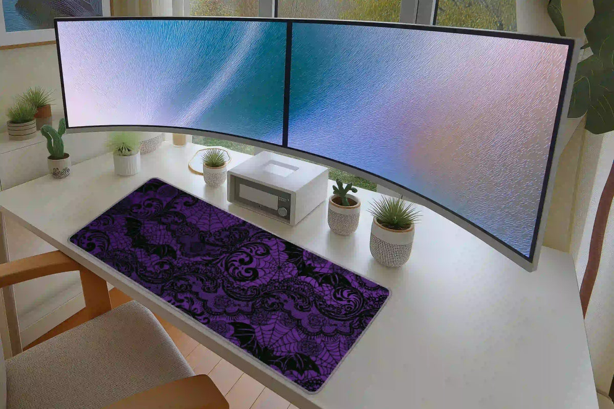 Purple gothic lace mat in a dual-monitor desk setup, showing black bat, rose and spiderweb motifs