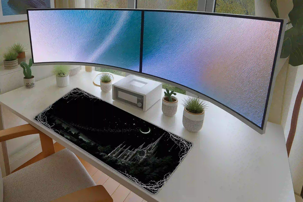Black gothic cathedral desk mat with a thorn frame on a white desk beneath dual monitors
