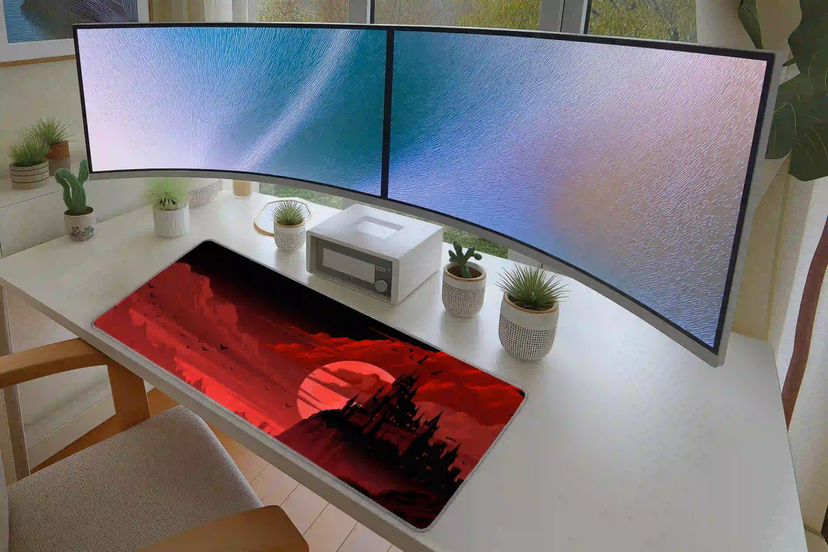 Red moon and black castle desk mat on a white desk below dual monitors, showing the full landscape