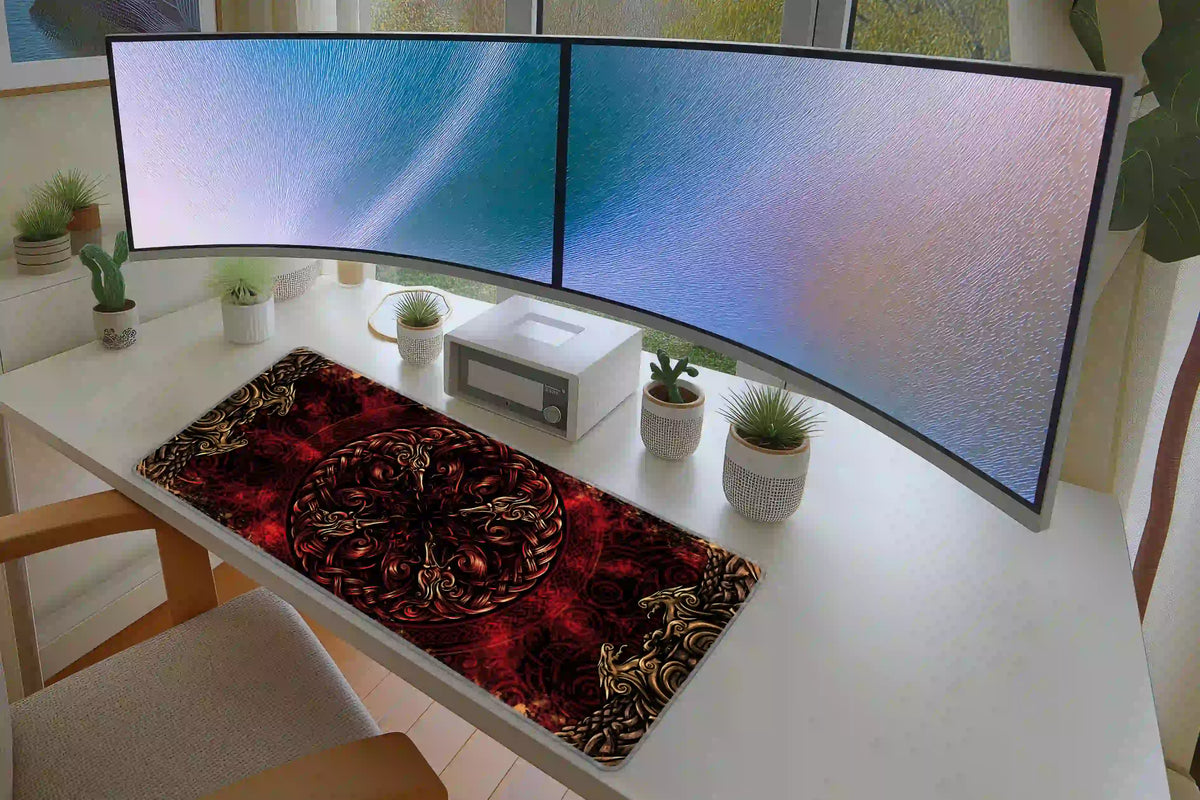 Red Norse dragon knot desk mat shown on a white desk with dual monitors and small potted plants