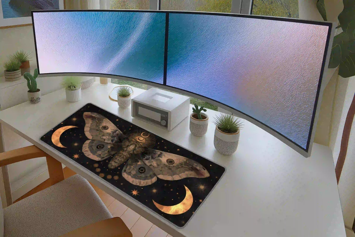 Celestial moth desk mat on a white desk with two monitors, displaying golden moons and patterned sepia wings