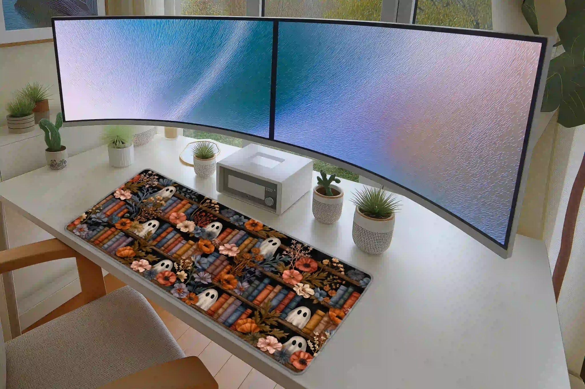 Full desk setup with the cozy ghost floral Halloween library mat beneath a keyboard and mouse