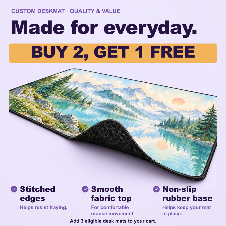 Mountain lake desk mat with a corner lifted to show the rubber base; graphic highlights stitched edges and a smooth fabric surface.
