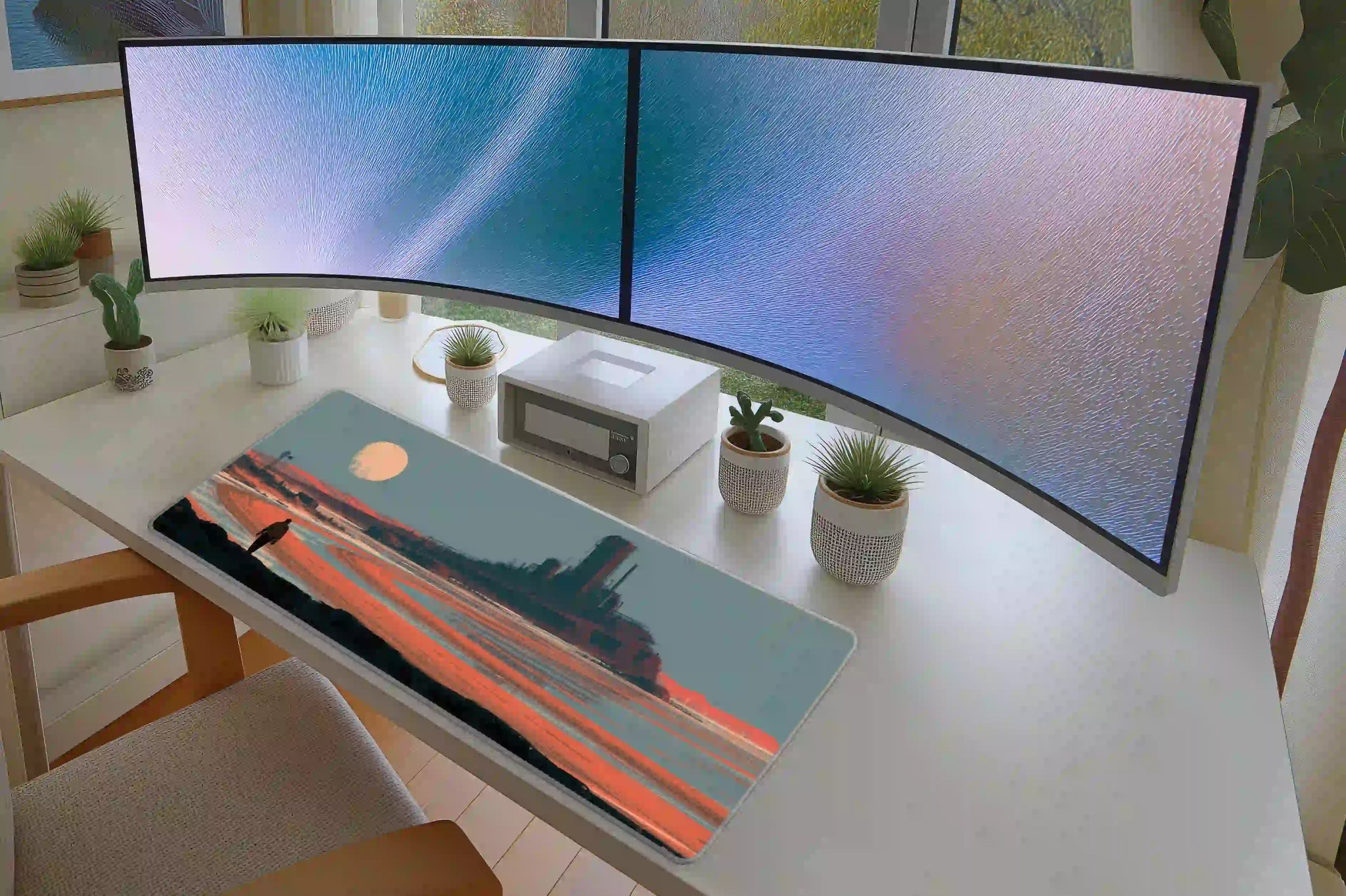 Office desk setup featuring the sci-fi desert fortress landscape extended mouse pad