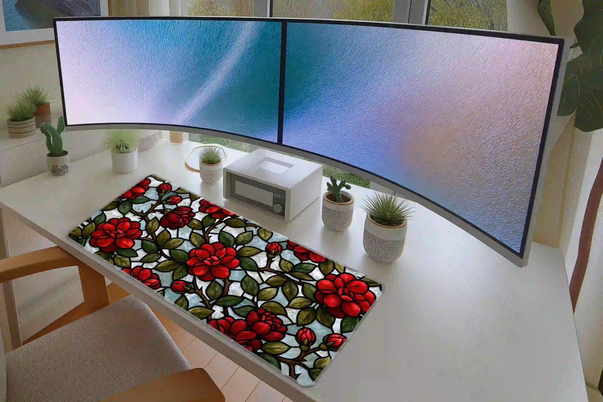 Red rose desk mat on a white desk beneath monitors, showing the full stained glass style floral arrangement