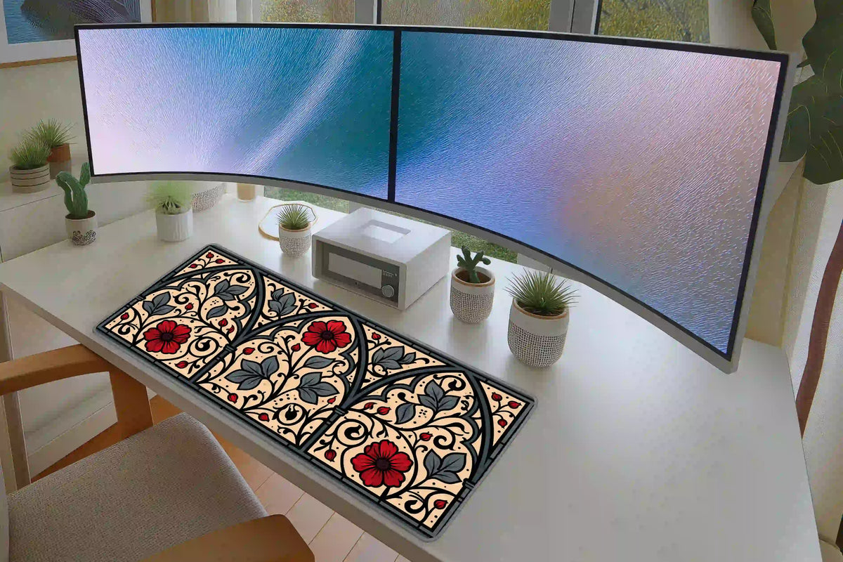 Gothic floral arch desk mat on a white desk with monitors, showing red flowers arranged inside three pointed panels
