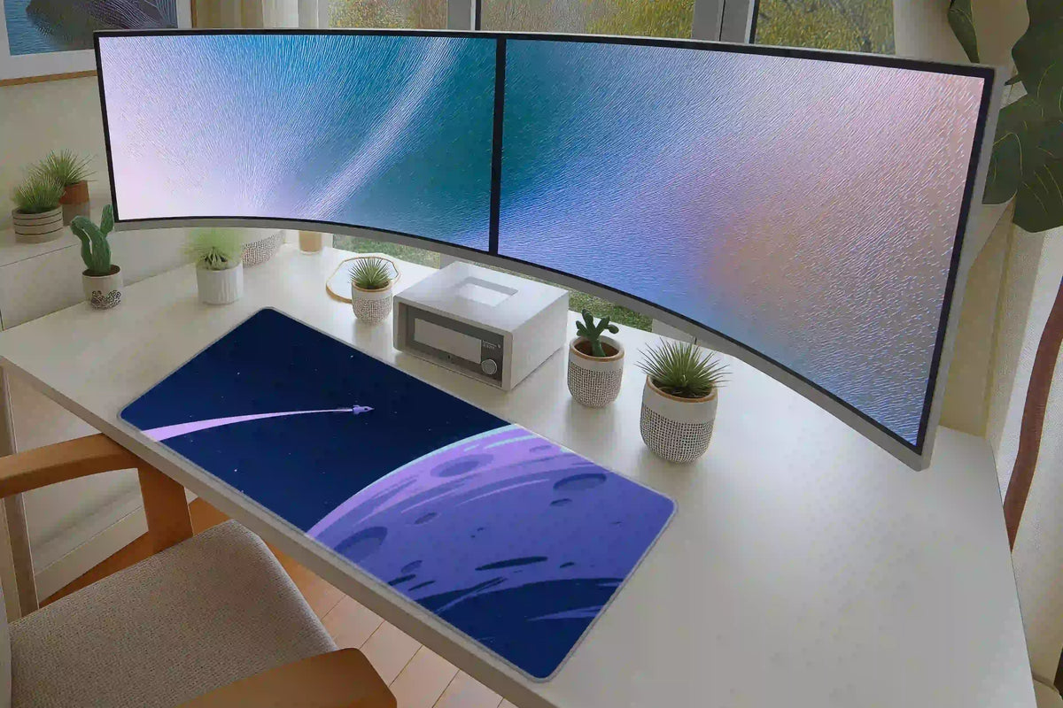 Blue rocket and moon desk mat on a white desk under curved monitors, showing the open star field and large lunar curve