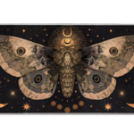 Celestial desk mat with a large sepia moth, golden crescent moons and starbursts against a black background