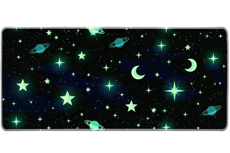 Celestial desk mat with mint-green stars, crescent moons and teal ringed planets on a dark blue-black sky