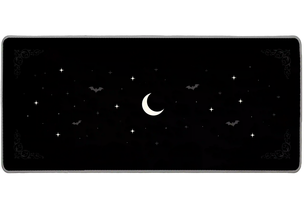 Minimal black desk mat with a pale crescent moon, small white stars, subtle gray bats and gothic corner scrollwork