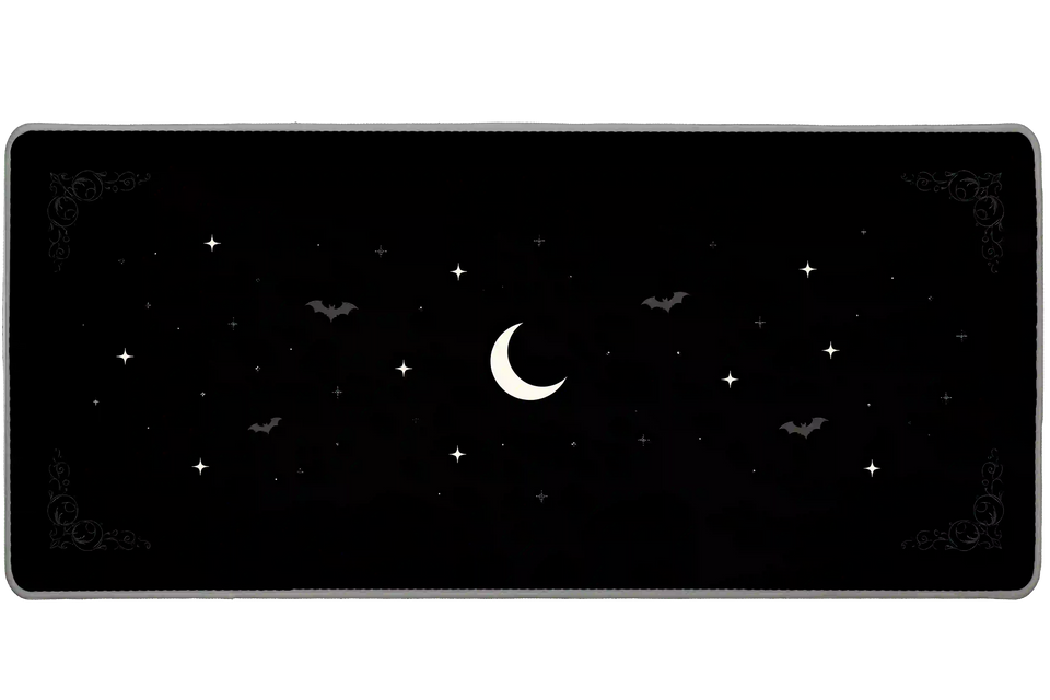 Minimal black desk mat with a pale crescent moon, small white stars, subtle gray bats and gothic corner scrollwork