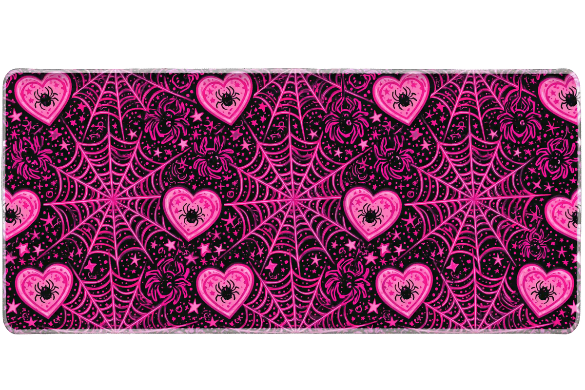 Black and hot pink desk mat patterned with spiderwebs, spiders inside hearts and scattered stars