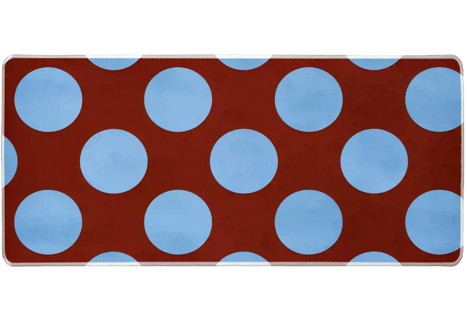 Wide Retro Polka Dot desk mat with powder-blue circles across a warm rust-red field